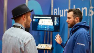 people standing and talking in front of a tv