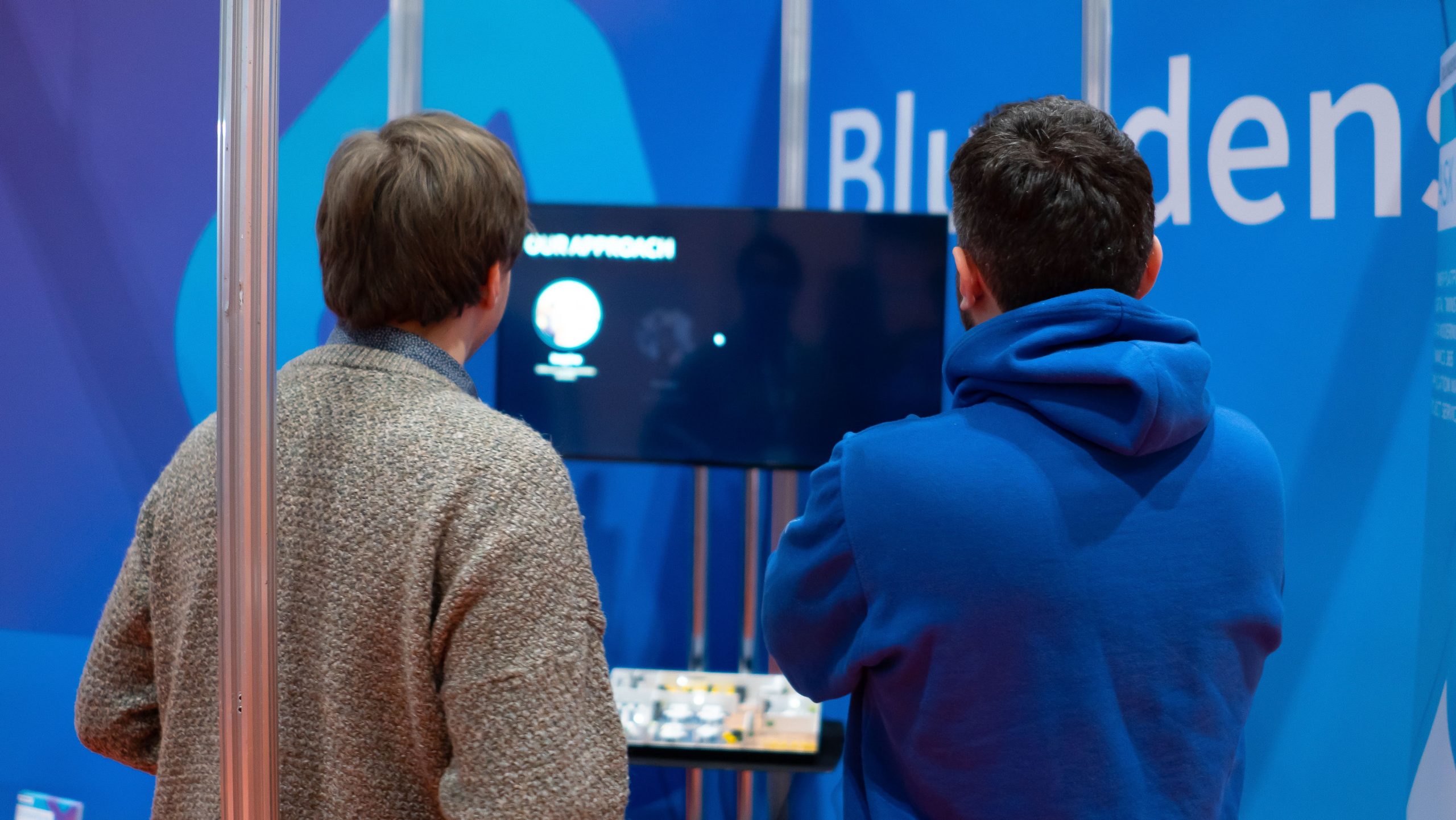 people standing and watching a tv